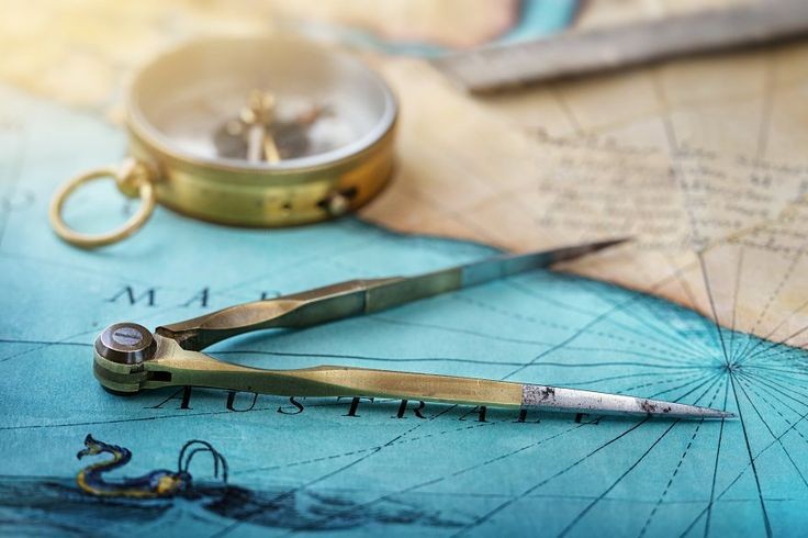 An old geographic map with navigational tools_ compass, divider, ruler, protractor_ View of the workplace of ship's captain